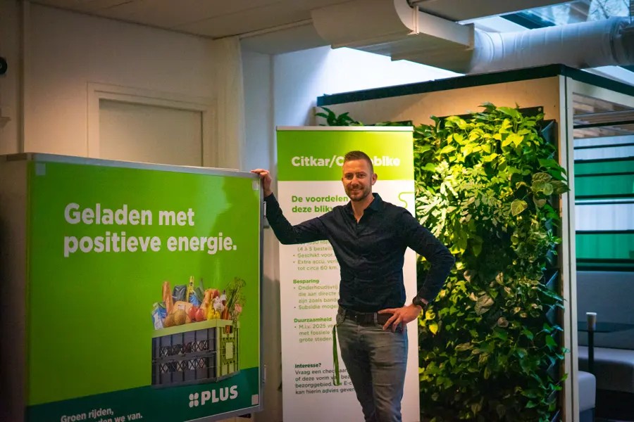 Jack Van Nrg Office Naast Een Banner Van De Plus (1)