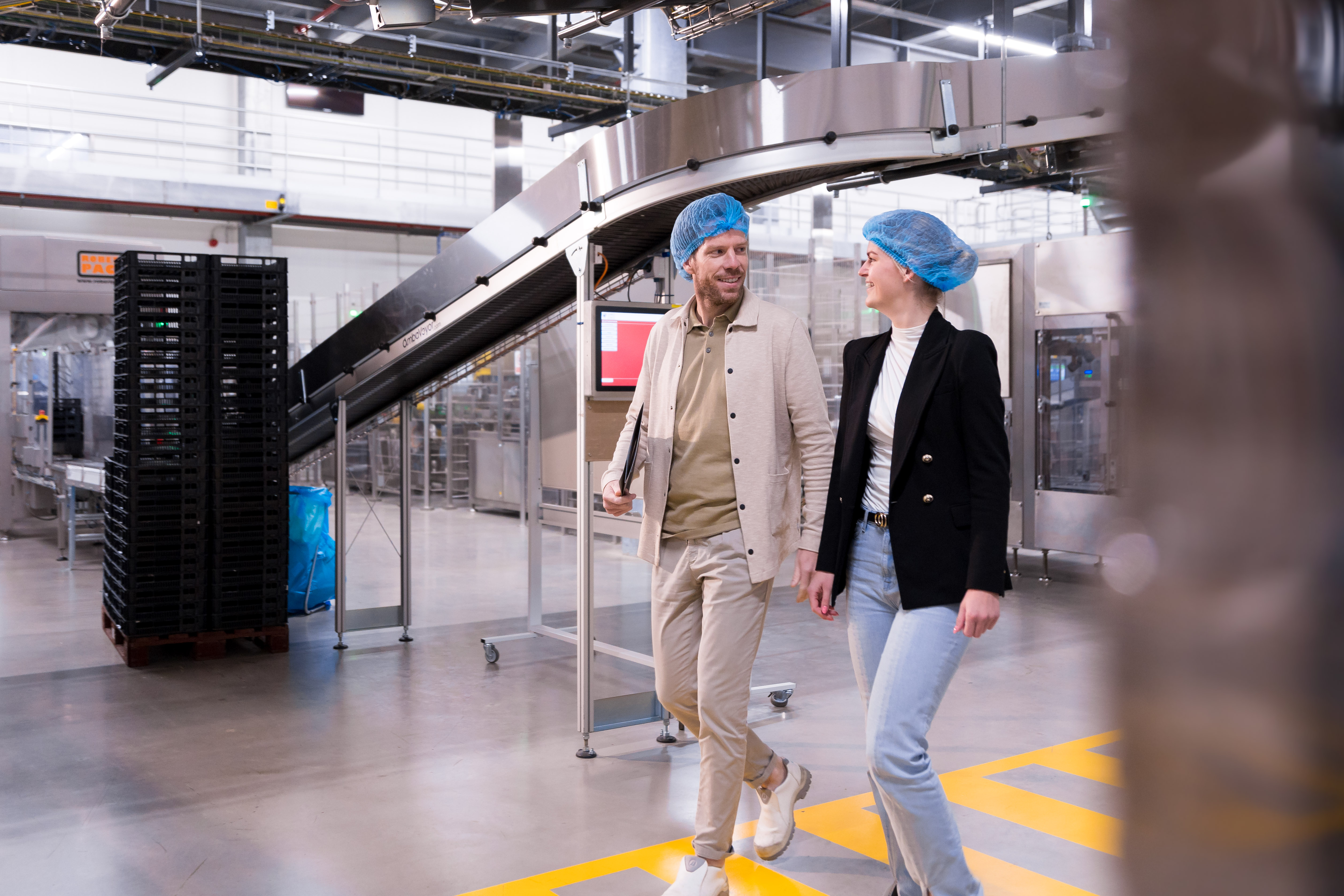 twee mensen van nrg office lopen lachend door een supply chain omgeving.jpg