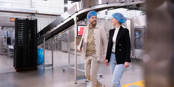 twee mensen van nrg office lopen lachend door een supply chain omgeving.jpg